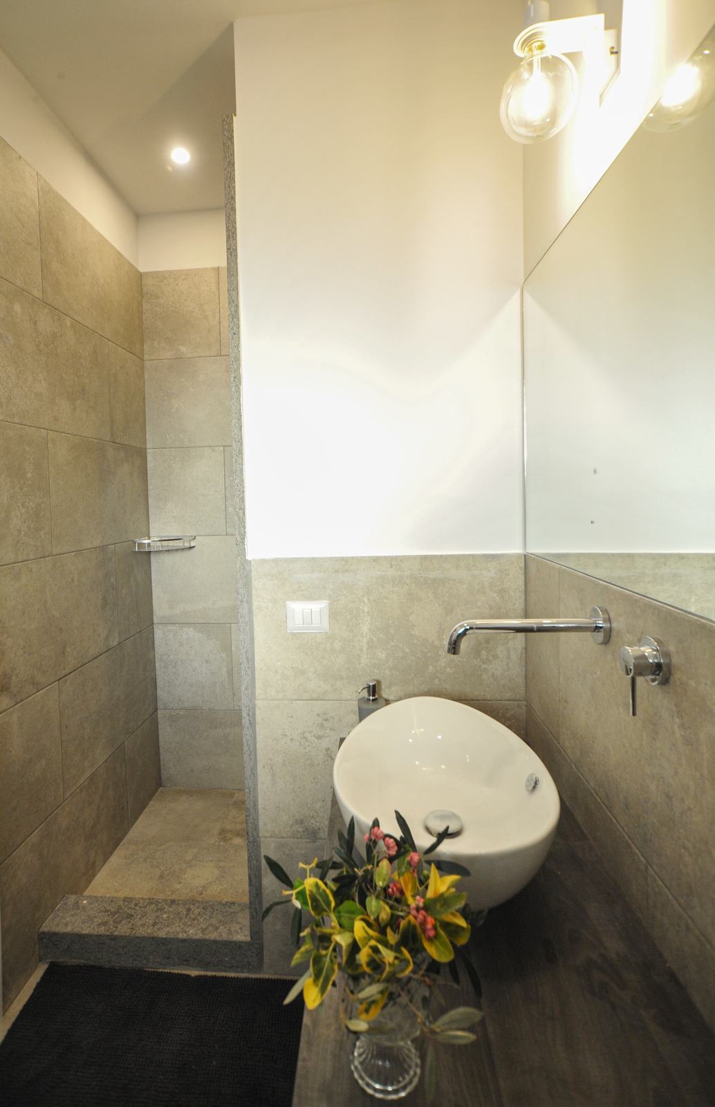 Il bagno con lavabo in appoggio e doccia