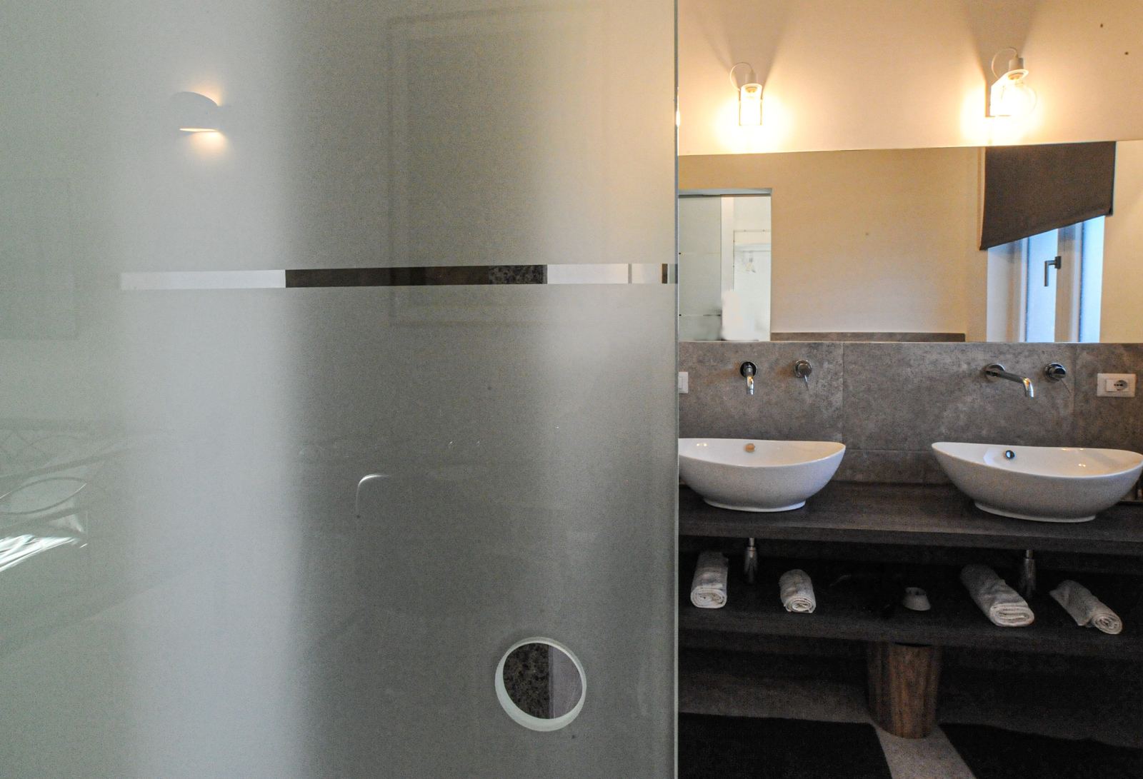 Il bagno con doppio lavabo, visto dalla porta scorrevole in vetro