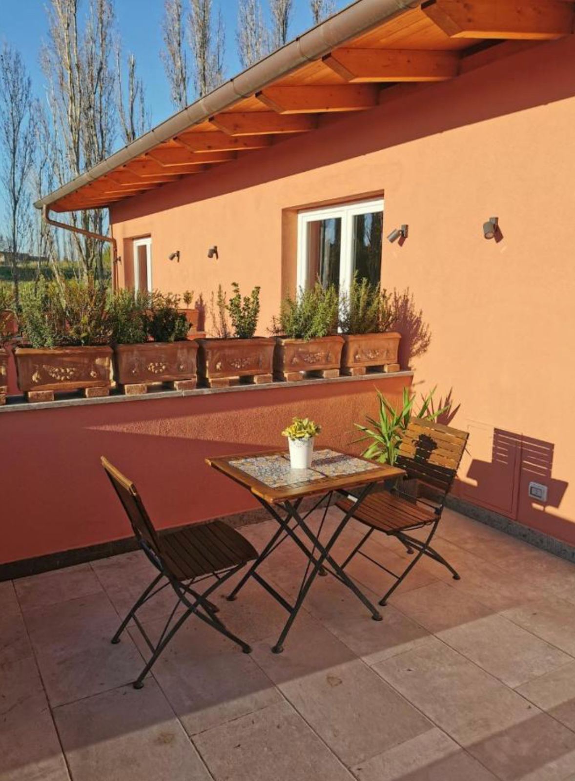 Tavolo e sedie sulla terrazza del primo piano, al sole